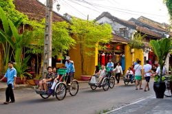Touristes en Tuk-Tuk dans les rues d'Hoi An